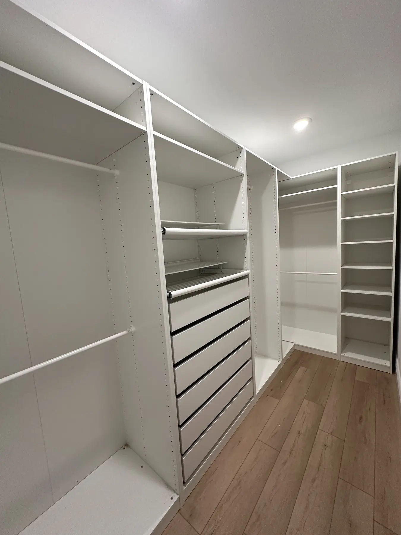 Walk-in closet with fitted shelving and drawer storage